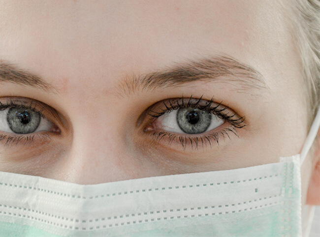 Eine Medizinstudentin trägt eine Schutzmaske im Gesicht.
