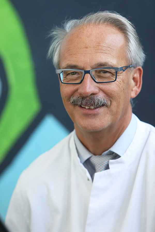 Ein Porträt von Prof. Wolfgang Kölfen in einem weißen Arztkittel.