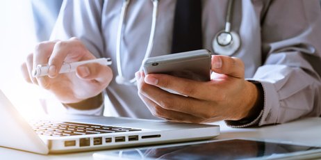 Praxis der Zukunft: Eine Ärztin sitzt vor ihrem Laptop und wertet Patientendaten aus.