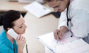 Ein Arzt checkt mit einer medizinischen Fachangestellten den Terminkalender.