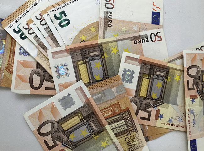 Ein ganzes Bündel an 50-Euro-Scheinen liegt auf einer Unterlage ausgebreitet.