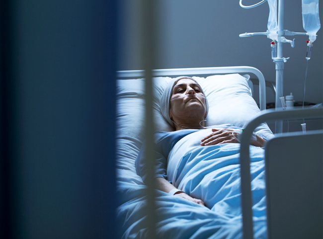 Eine sterbenskranke Frau liegt in einem Krankenhausbett.