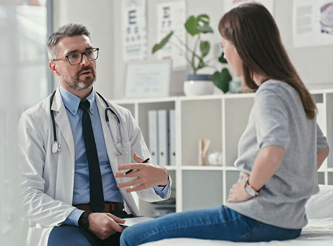 Ein Arzt ohne Doktortitel spricht mit seiner Patientin.