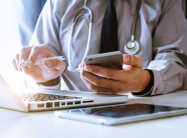 Praxis der Zukunft: Eine Ärztin sitzt vor ihrem Laptop und wertet Patientendaten aus.