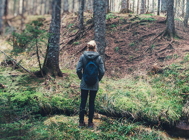 Eine junge Ärztin spaziert durch den Wald.