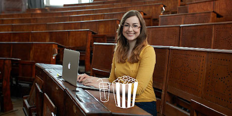 Frau sitzt in einem Hörsaal mit ihrem Laptop mit einer Zeichnung von Popcorn