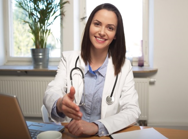 Eine Ärztin mit einem weißen Kittel und Stethoskop.