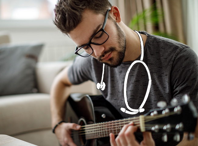 Ein junger Arzt spielt Gitarre, um sich vom Stress in der Praxis zu erholen.